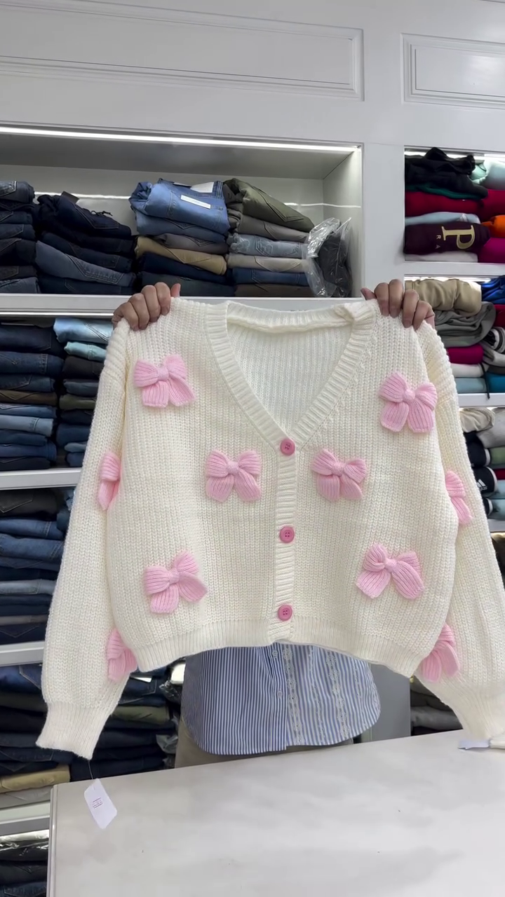 Cream Chunky‑Knit Cropped Cardigan with 3D Pink Bow Appliqués and Contrast Buttons for Cute Winter Looks” 🎀