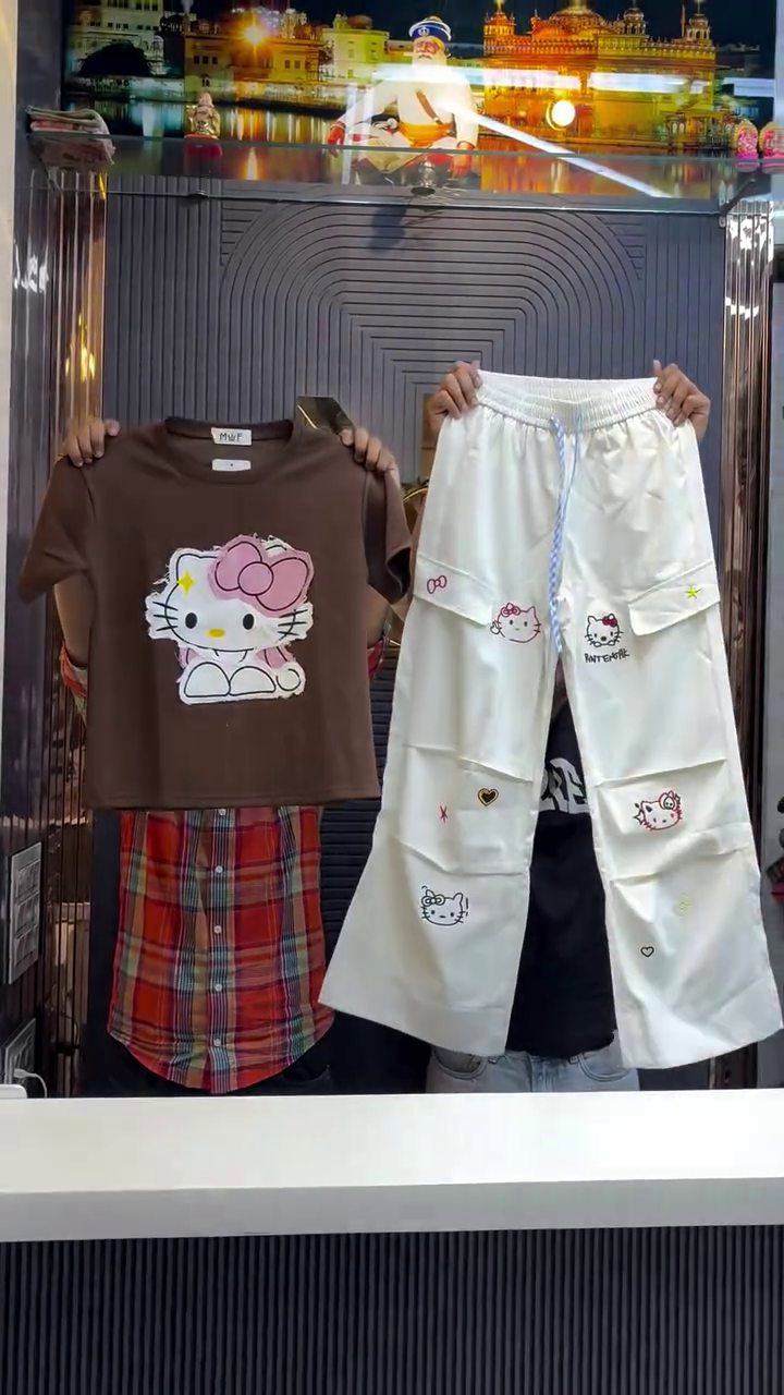 Red Short-Sleeved Hello Kitty Graphic Shirt Paired with White Pants Featuring Multiple Hello Kitty Prints, Stars, Hearts, and Bows Playful Character-Themed Ensemble ❤️👕👖🎀✨
