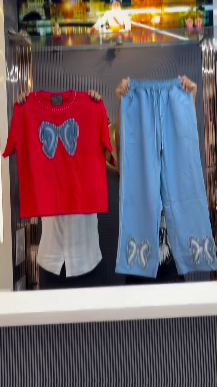 White Short-Sleeved T-Shirt with Large Blue Bow and Pearl Detailing Coordinated with Light Blue Pants Featuring Matching Bow and Beaded Side Seams Modern Statement Ensemble 🤍👕🎀👖✨