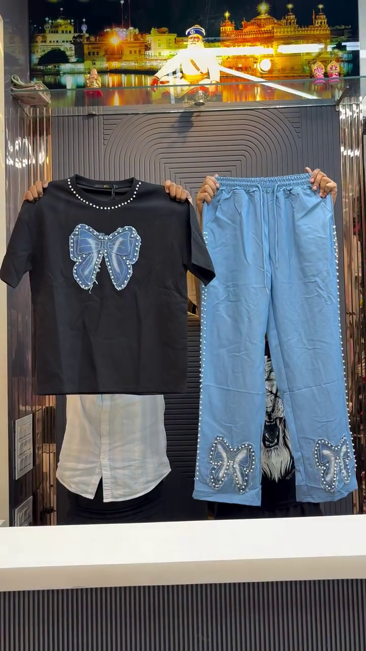 White Short-Sleeved T-Shirt with Large Blue Bow and Pearl Detailing Coordinated with Light Blue Pants Featuring Matching Bow and Beaded Side Seams Modern Statement Ensemble 🤍👕🎀👖✨