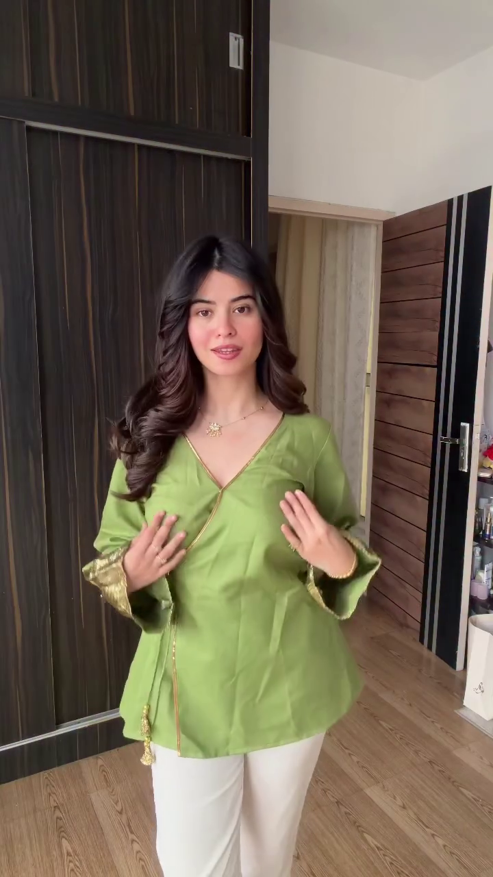 Green Wrap-Style Top with Golden Embellishments, Tassel Tie, and Floral Pendant Necklace Elegant Contemporary Outfit 🌿👕✨